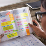 Event Planning on a Budget: How I Pulled Off a Successful Event Without Breaking the Bank Businesswoman Looking At List Of Business Work In Diary With Calendar On Desk compiled by Odeya event center